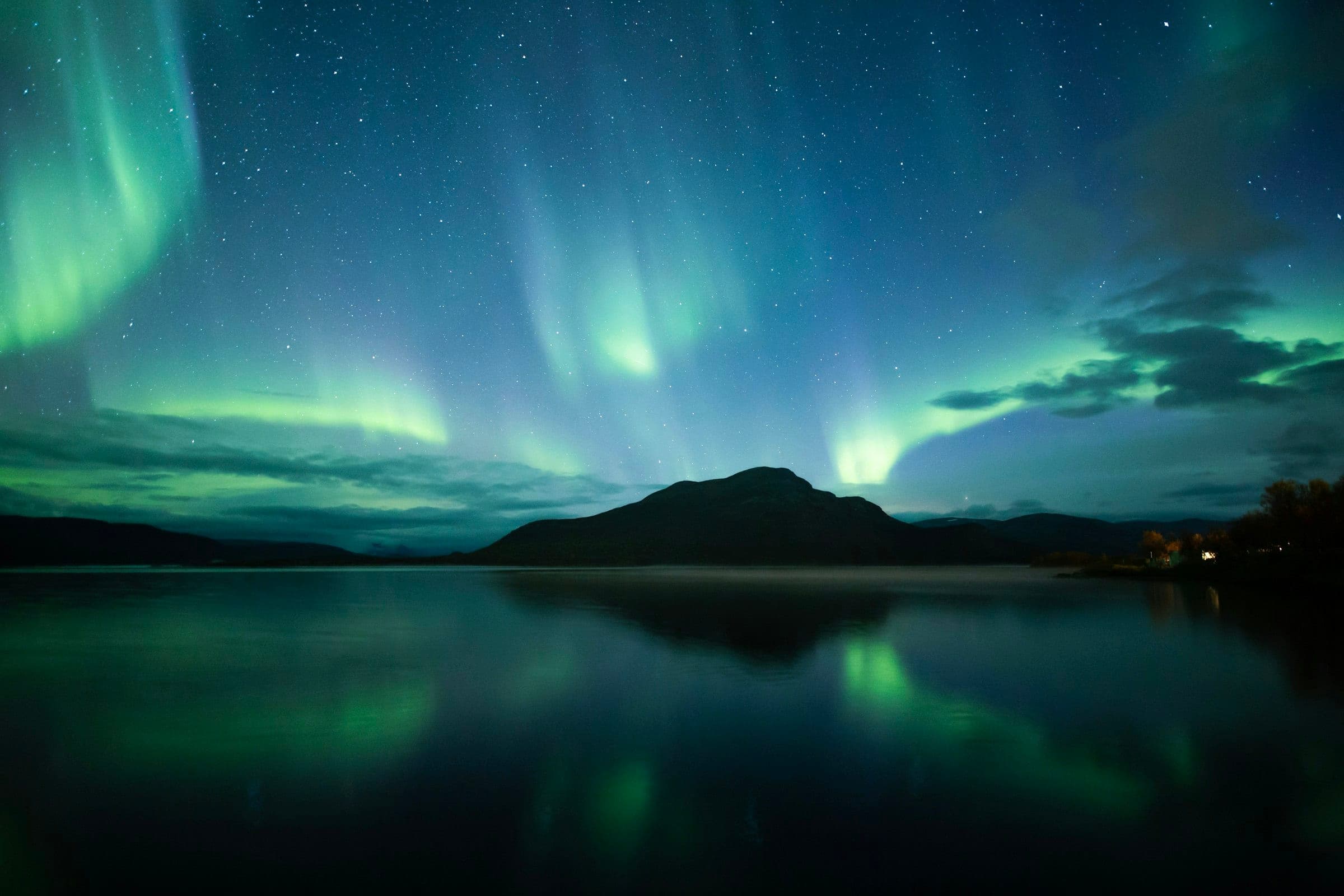 The northern lights over a still lake in Finnish Lapland
